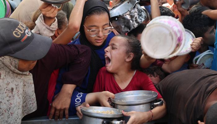 فلسطينيون يصطفون للحصول على وجبة بمخيم للنازحين في غزة