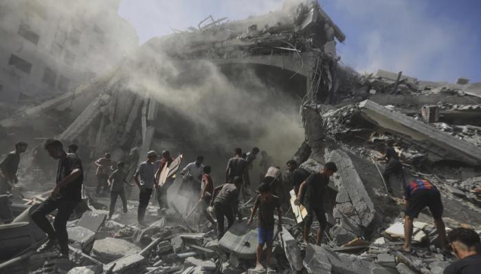 فلسطينيون يبحثون بين أنقاض مبنى قصفته إسرائيل في غزة