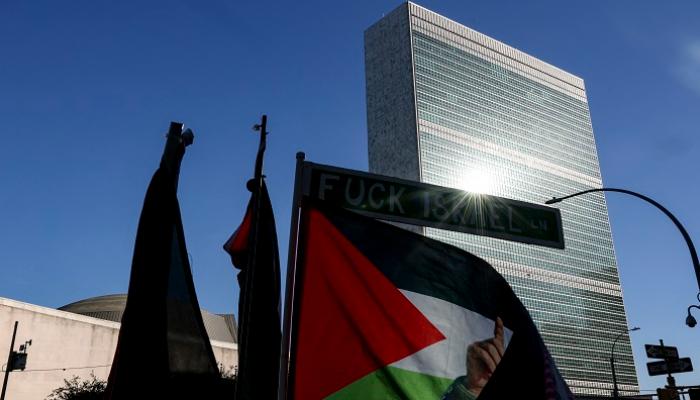 متظاهرون مؤيدون للفلسطينيين يرفعون لافتة مناهضة لإسرائيل خارج مقر الأمم المتحدة 