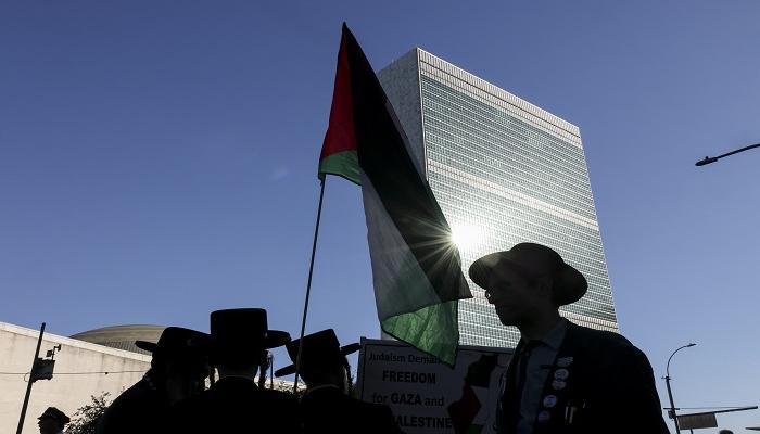 متظاهرون مؤيدون للفلسطينيين يرفعون لافتة مناهضة لإسرائيل خارج مقر الأمم المتحدة 