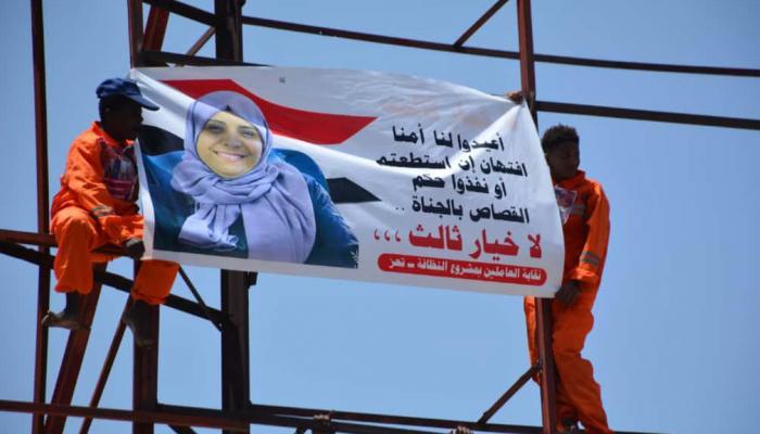 متظاهران يرفعان صورة المشهري