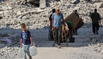 طفل فلسطيني في غزة يحمل حاويات مياه صغيرة