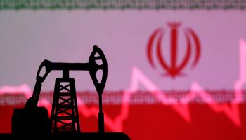 منصة برية للتنقيب عن النفط وفي الخلفية علم إيران (رويترز)
