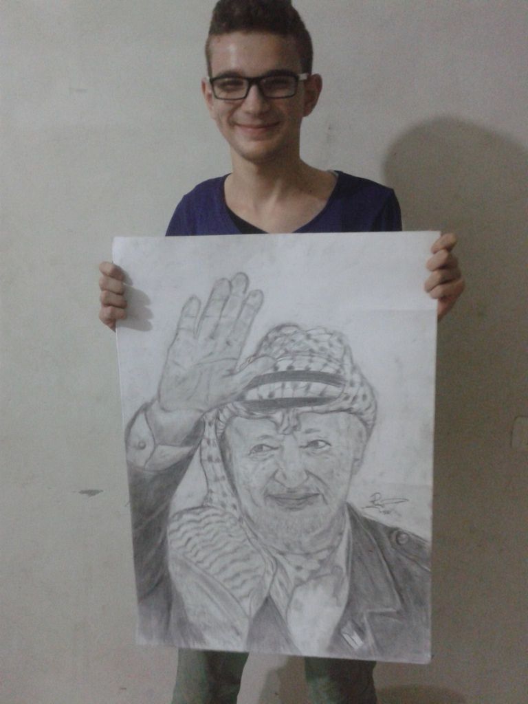 الشاب رامى أمام أحد أعماله