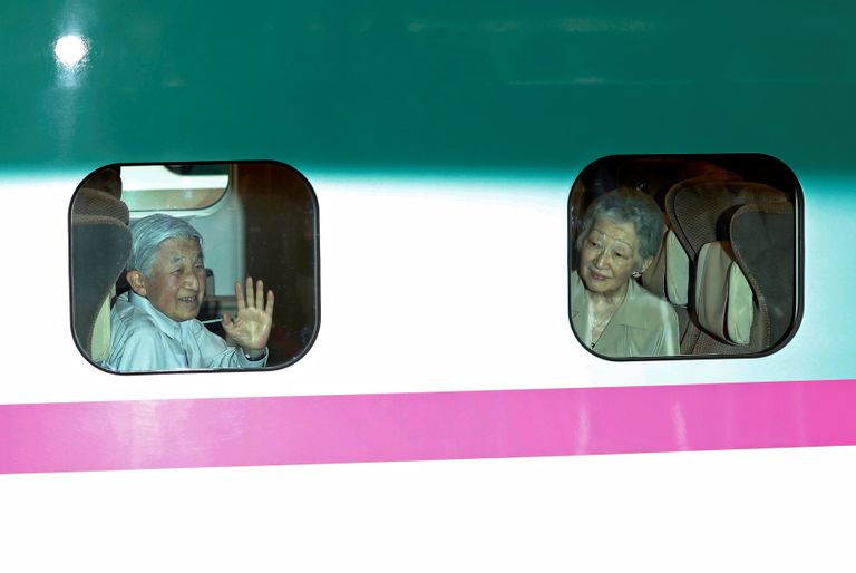 إمبراطور اليابان مع زوجته يلوح للمهنئين من حوله في محطة قطار طوكيو