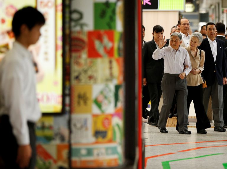 إمبراطور اليابان مع زوجته يلوح للمهنئين من حوله في محطة قطار طوكيو