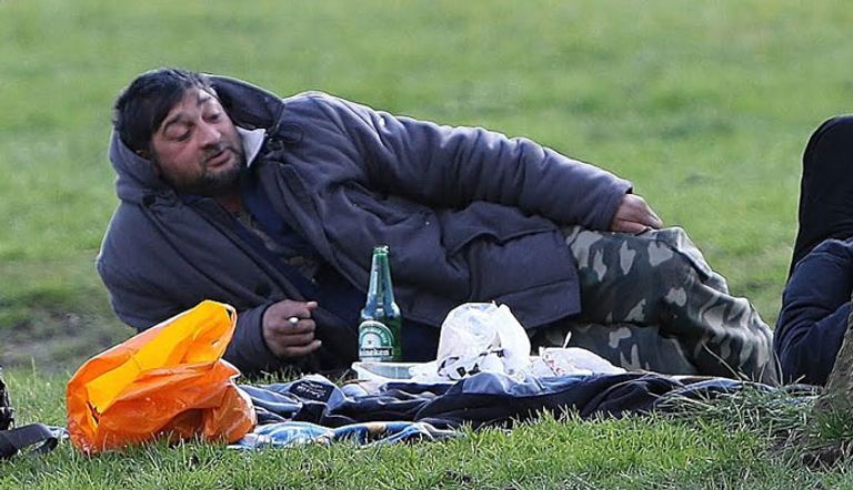 مهاجرون أثناء افتراشهم الحديقة