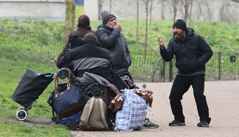 مهاجرون أثناء افتراشهم الحديقة