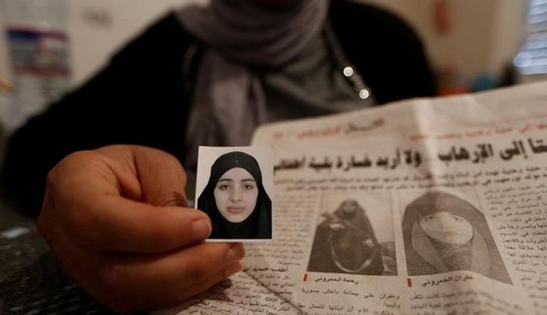 ألفة (39 عاما) تعرض صورة ابنتيها رحمة (في اليمين) زوجة نورالدين شوشان الذي قتل أثناء ضربة جوية أمريكية في ليبيا وغفران المنشورتين في صحيفة