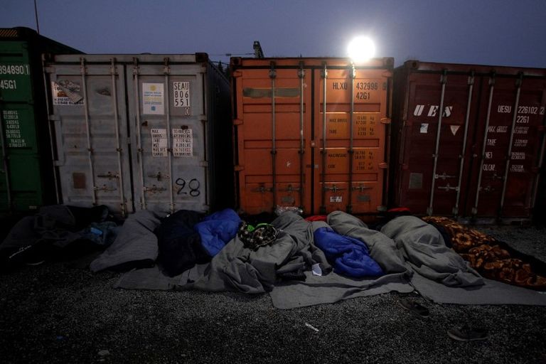 مهاجرون ينامون بجوار حاويات بالقرب من الحدود المقدونية اليونانية - رويترز