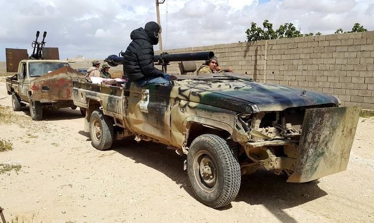 فراد من القوات المسلحة الموالية للحكومة في شرق ليبيا على عربات مصفحة - رويترز