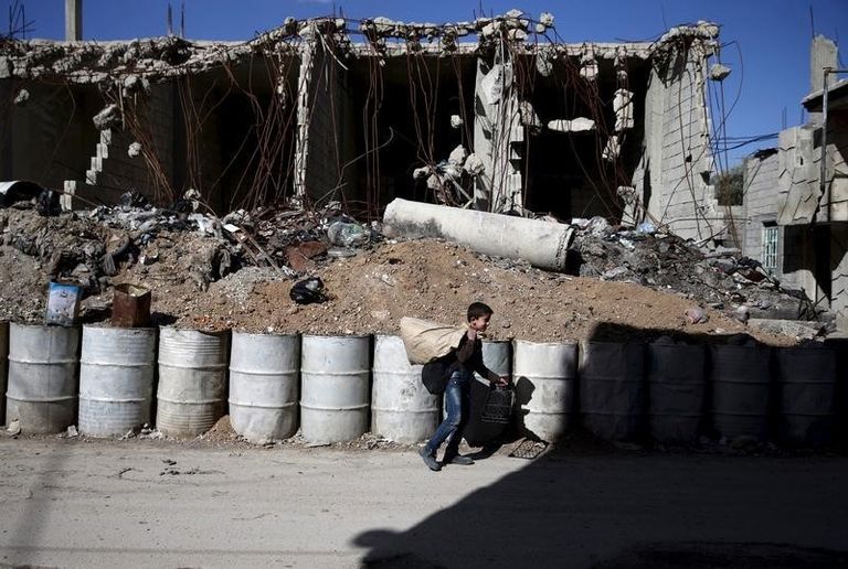 طفل يسير بجوار مبنى مهدم في دمشق - رويترز