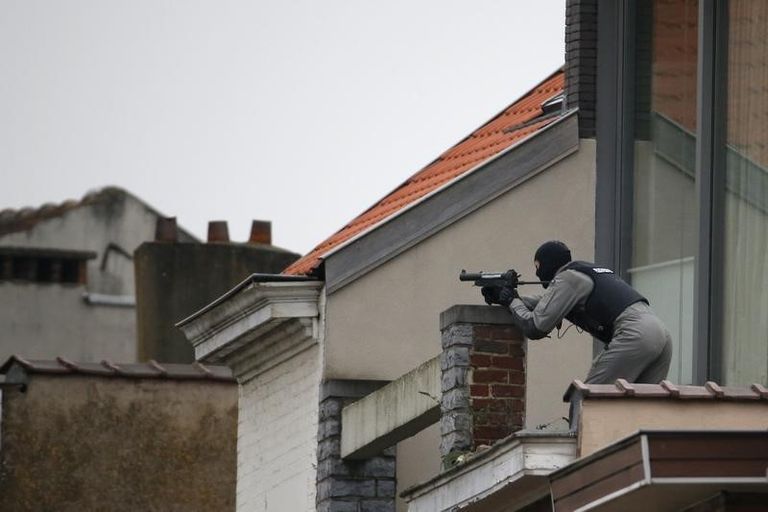 رجال شرطة بلجيكي على سطح أحد المنازل في حي فورست في بروكسل - رويترز