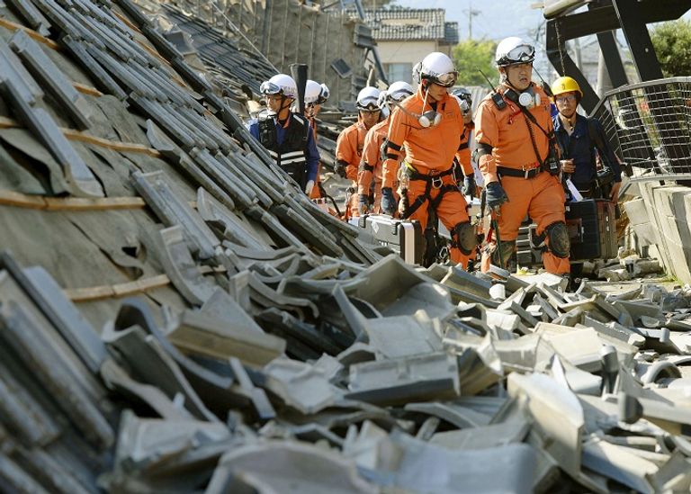 رجال إنقاذ يابانيون وسط حطام مبنى تدمر في زلزال بمقاطعة كوماموتو (رويترز)