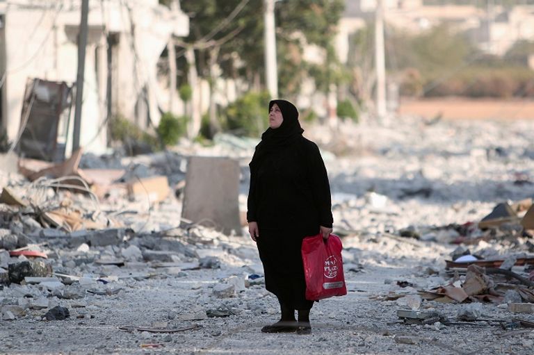 سورية من منبج تطالع أطلال حيها الذى دمرته المعارك