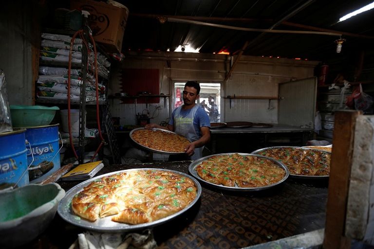 لاجئي سوري في محل للحلويات بخيم في الأردن (رويترز)