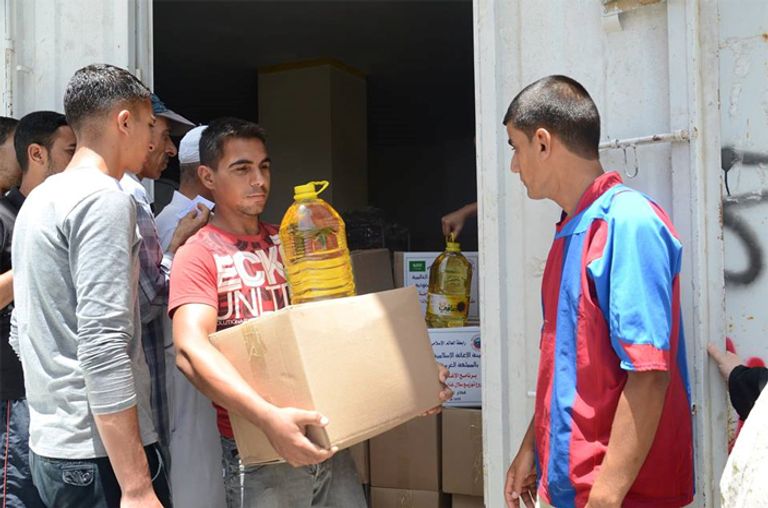  أحد الفلسطينيين يتلقى مساعدات غذائية - أرشيفية