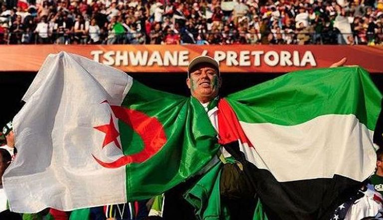 مشجع جزائري يحمل علم الدولتين