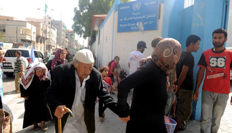   فلسطينيون يقفون أمام إحدى مؤسسات الأونروا في غزة