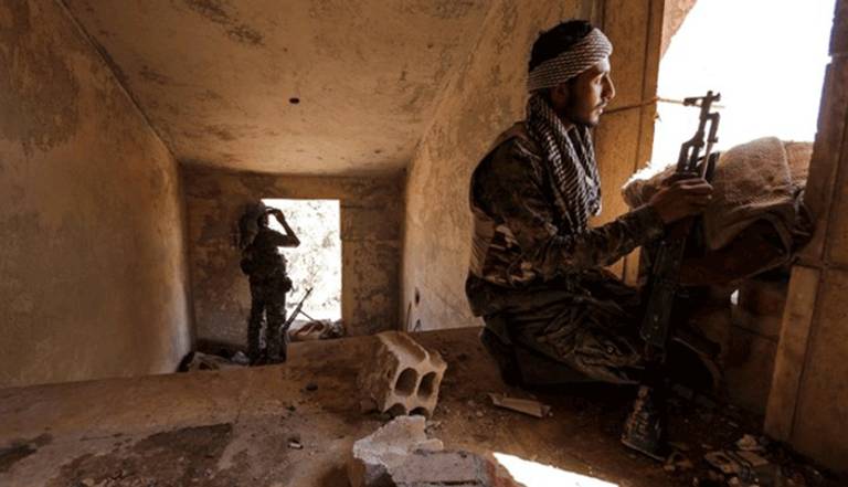 مقاتلان كرديان داخل منزل مهجور في أحد أحياء مدينة الحسكة السورية