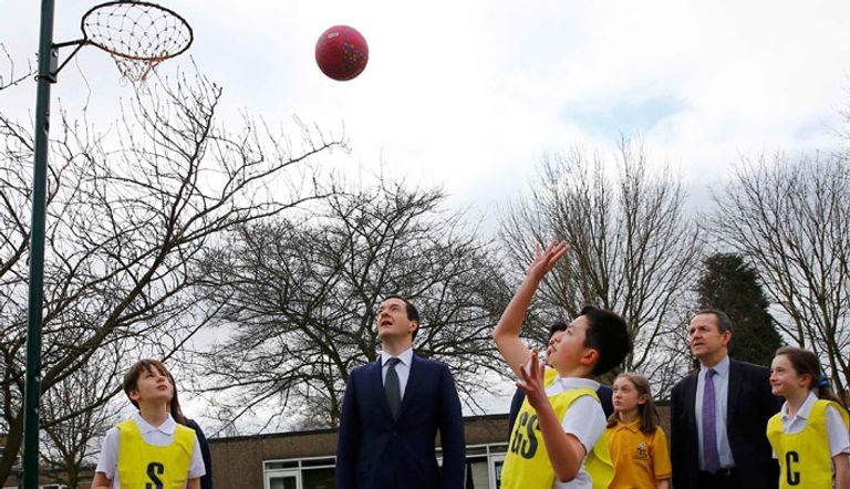 مسؤول  بريطاني يتحدث للتلاميذ خلال تدريب كرة السلة  في المدرسة الابتدائية