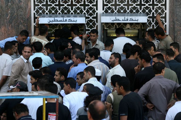  موظفون بانتظار تلقي رواتبهم أمام بنك فلسطين بغزة