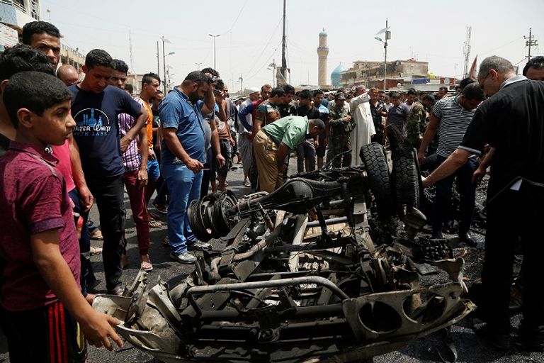 عراقيون في موقع تفجير السيارة المفخخة ببغداد (رويترز)
