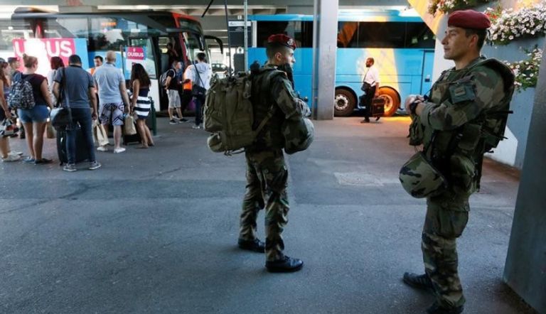 جنود فرنسيون يراقبون ركاب قبل ركوب حافلة في محطة حافلات في مدينة ليون