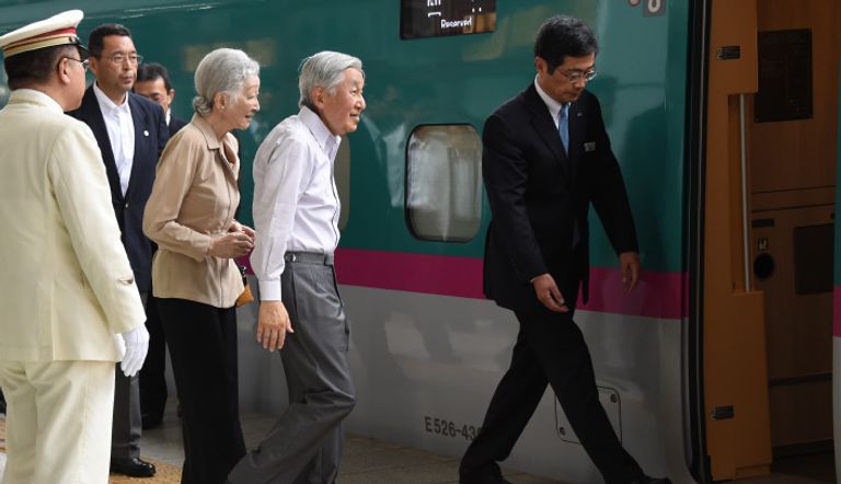 إمبراطور اليابان مع زوجته يلوح للمهنئين من حوله في محطة قطار طوكيو