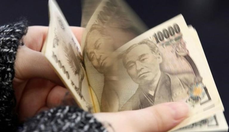 امرأة تعد عملات ورقية فئة 10 آلاف ين ياباني