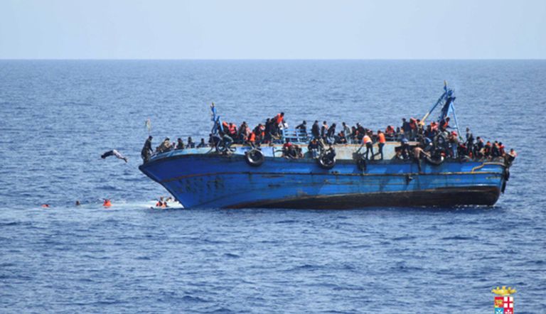 قارب يترنج ومهاجرون ولاجئون يقفزون منه إلى البحر