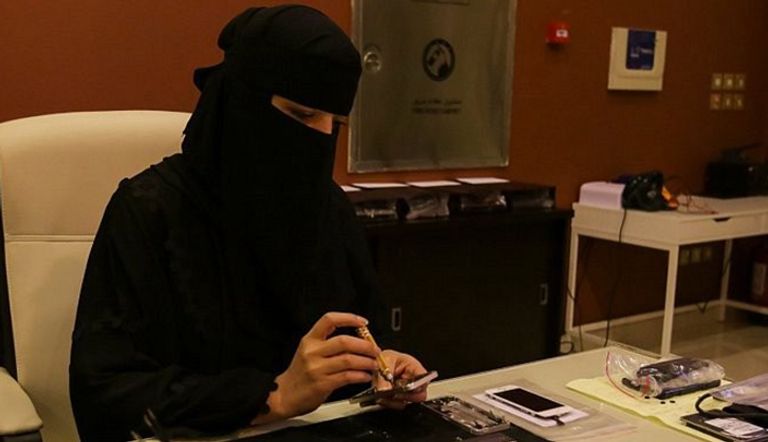 إحدى السيدات السعوديات تقوم بإصلاح الجوال