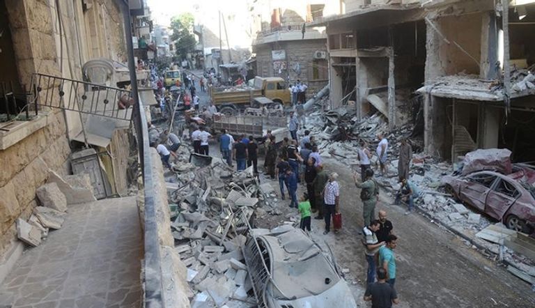 أشخاص يتفقدون دمارا في موقع قصفته المعارضة السورية في منطقة خاضعة لسيطرة الحكومة في مدينة حلب بسوريا