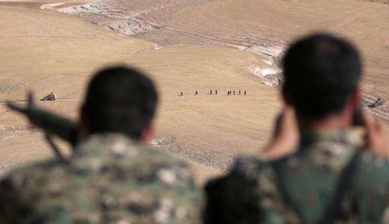 مقاتلون من قوات سوريا الديمقراطية يتمركزون في مواقعهم بينما يتقدم زملاؤهم صوب مدينة منبج السورية