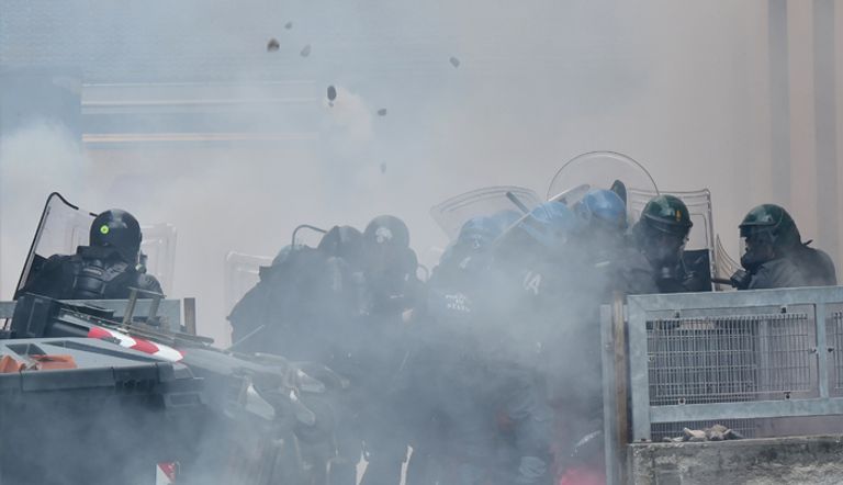 قوات الأمن الإيطالية تحمي أنفسها من حجارة المتظاهرين