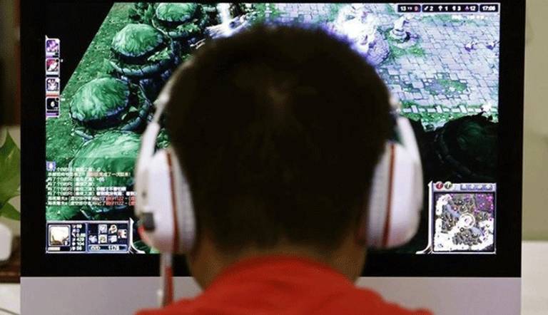 رجل يلعب لعبة على جهاز كمبيوتر في مقهى للانترنت في الصين