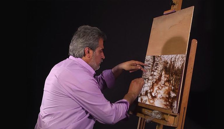 الفنان الأردني نياز المشني أمام لوحة من لوحاته