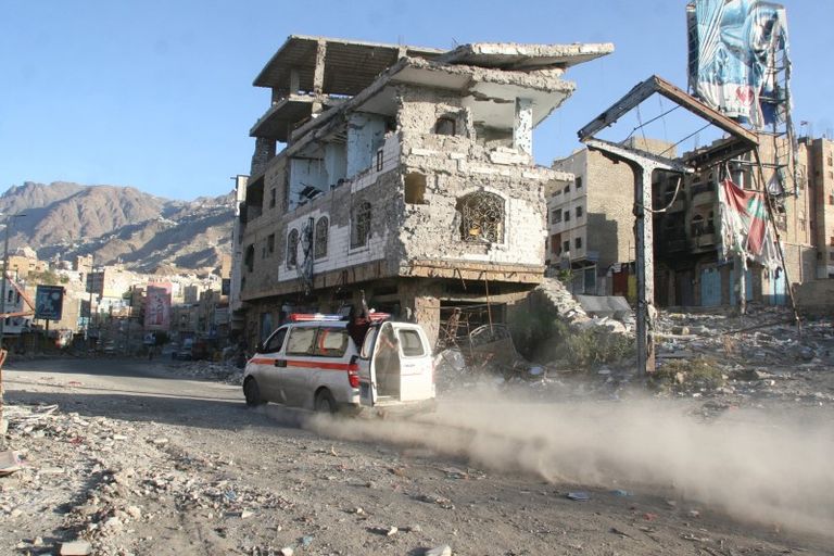 أحد سيارات الإسعاف تسير في منطقة تم قصفها في اليمن