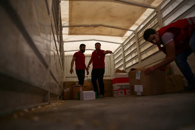  عمال إغاثة يقومون بنقل مساعدات في سوريا (رويترز)
