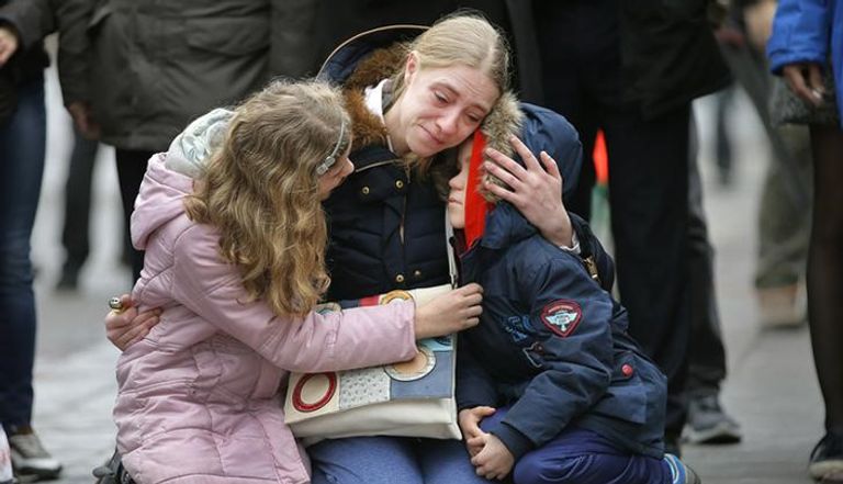 امرأة تحتضن طفليها في مراسم أقيمت حدادا على أرواح ضحايا هجمات بروكسل