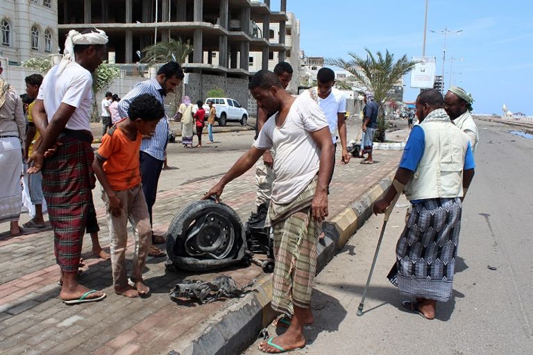 يمنيون تجعوا قرب موقع تفجير السيارة المفخخة بعدن (أ ف ب)