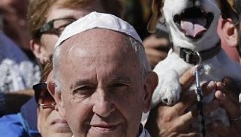 كلب مرح يبتسم خلف بابا الفاتيكان 