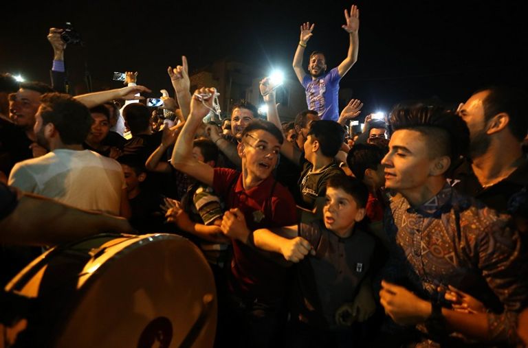 أطفال يحملون الشموع ابتهاجا بقدوم القوات العراقية