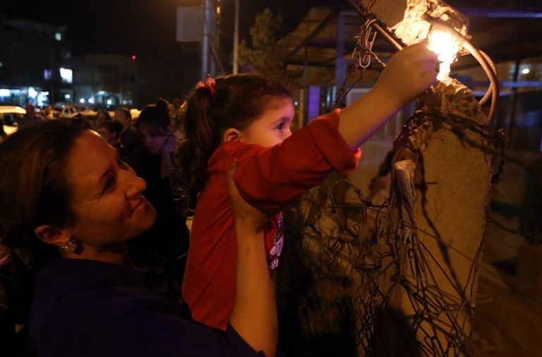 أطفال يحملون الشموع ابتهاجا بقدوم القوات العراقية