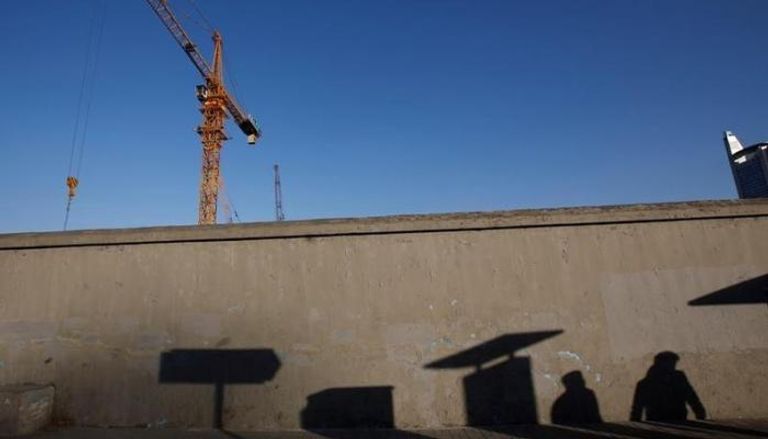 ظلال أشخاص على جدار في موقع بناء في بكين