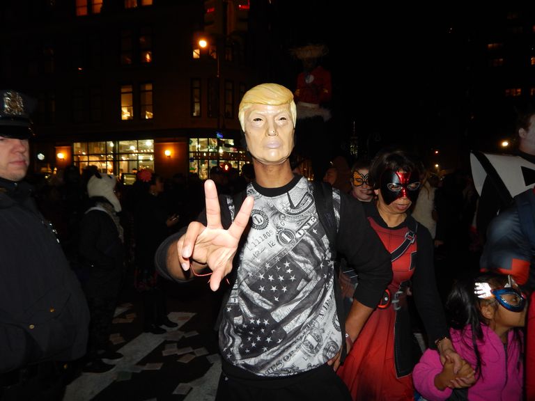 أحد المشاركين في الاحتفالات يرتدي قناع ترامب