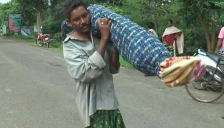 هندي لف جثمان زوجته في سجادة وحملها على كتفه