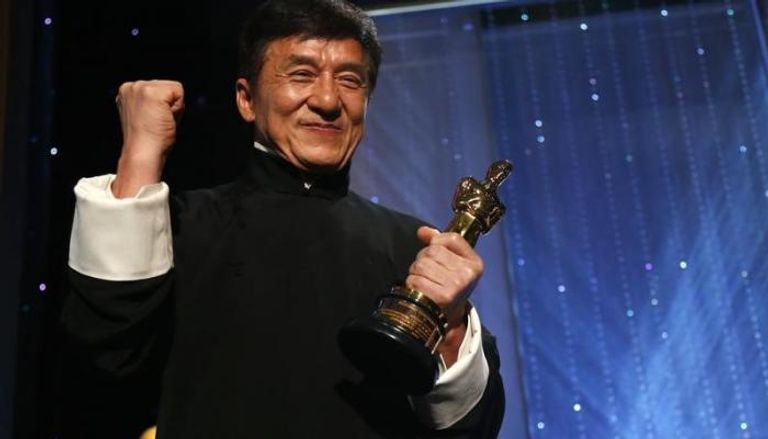 جاكي شان يقف لالتقاط الصور ممسكا بتمثال ذهبي حصل عليه في حفل توزيع جوائز الأوسكار الشرفية