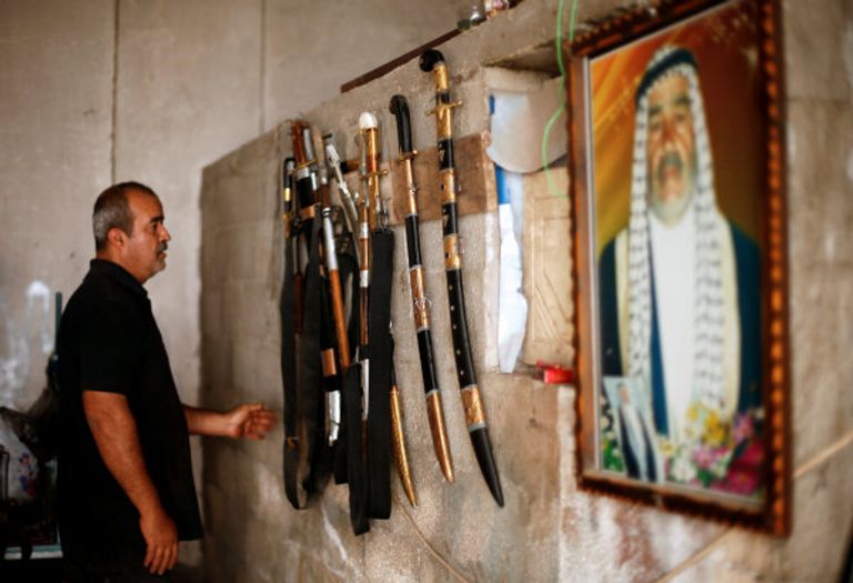 معين أبو وادي يفحص أبعاد أحد السيوف (رويترز)