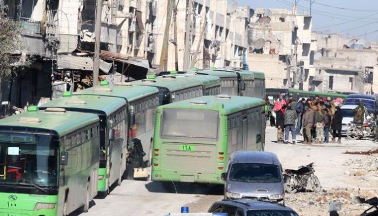 أشخاص يستقلون حافلات لإجلائهم من منطقة خاضعة للمعارضة في شرق حلب